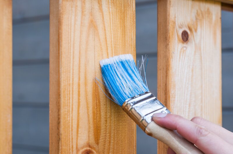 close-up of a paintbrush on a deck for staining/sealing