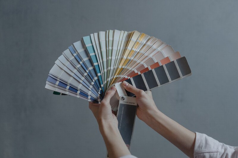 Person spreading out a large color palette for home painting options