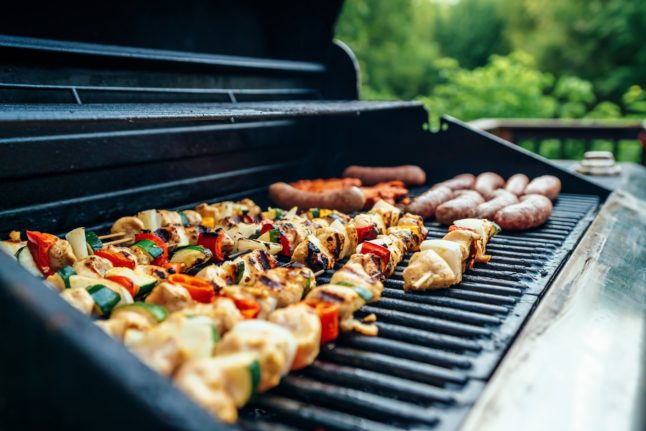 bratwurst and kabobs cooking on outdoor grill