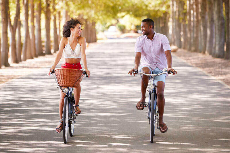 mixed couple riding bikes looking at each other
