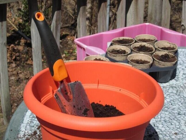 spade and dirt inside of a pot used for container gardening