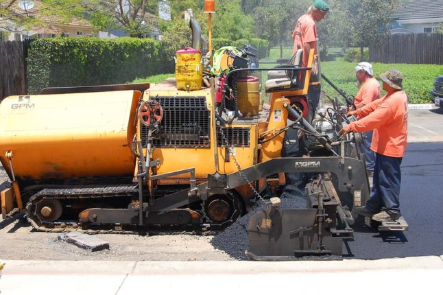 men standing with asphalt cold planer