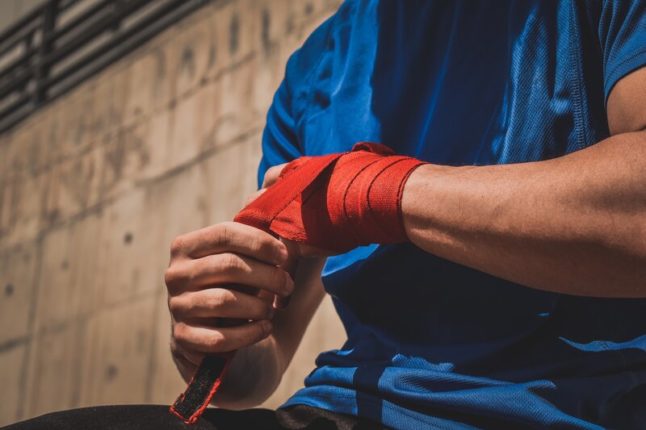 closeup of man wrapped bandage around hand