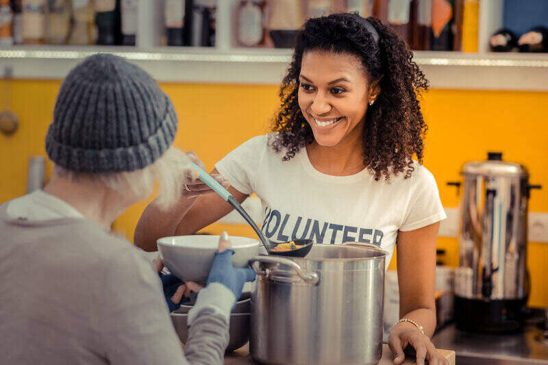 woman serving soup as a volunteer