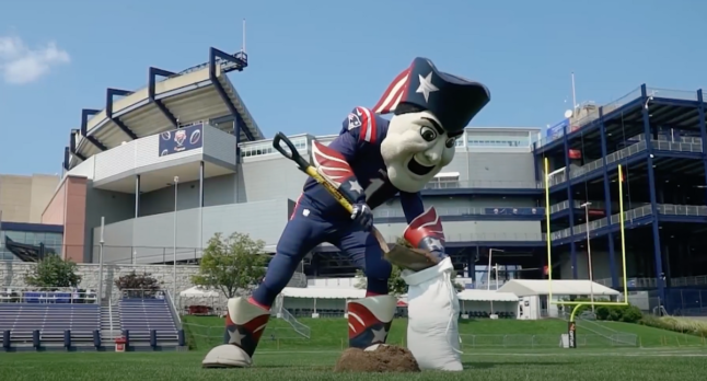 New England Patriot mascot shoveling dirt into a bag.