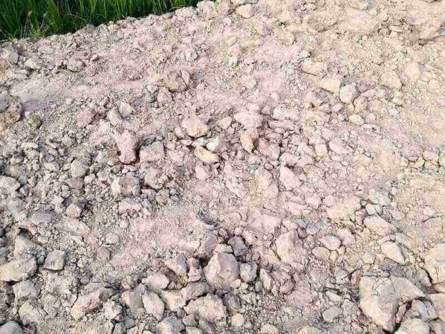 close-up of light-colored chalky soil with rocks mixed in