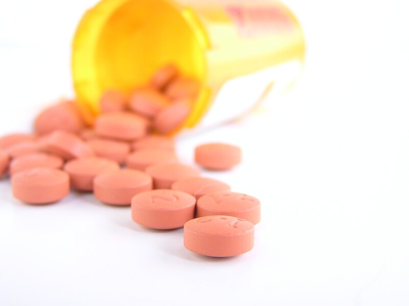 Prescription bottle of pills spilled out on the counter