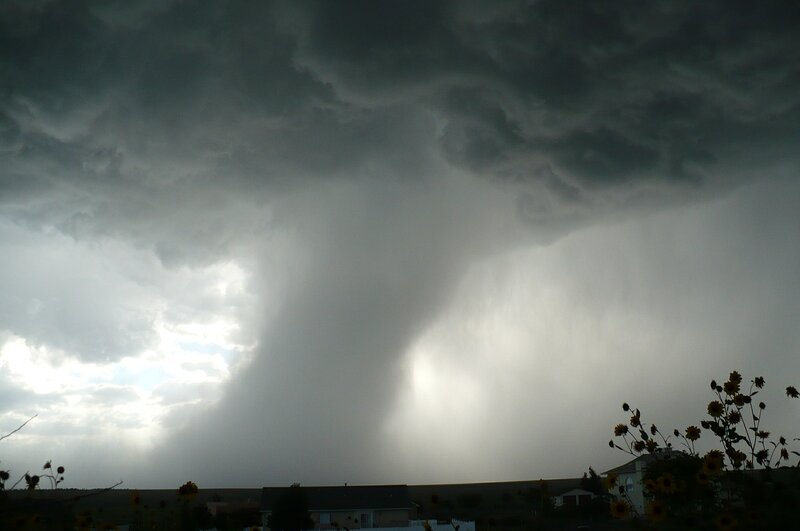 tornado in the background with a house in the foreground