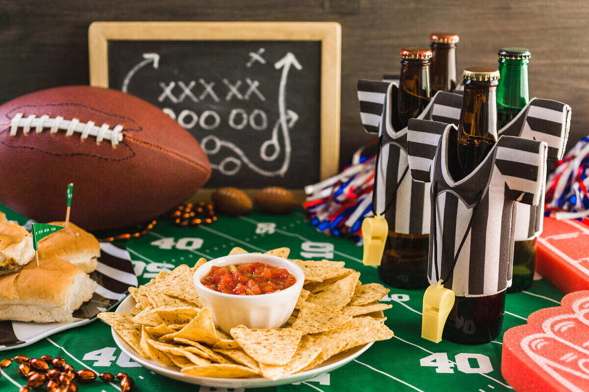 Super Bowl party fixins with beer, chips and salsa, and sandwiches.