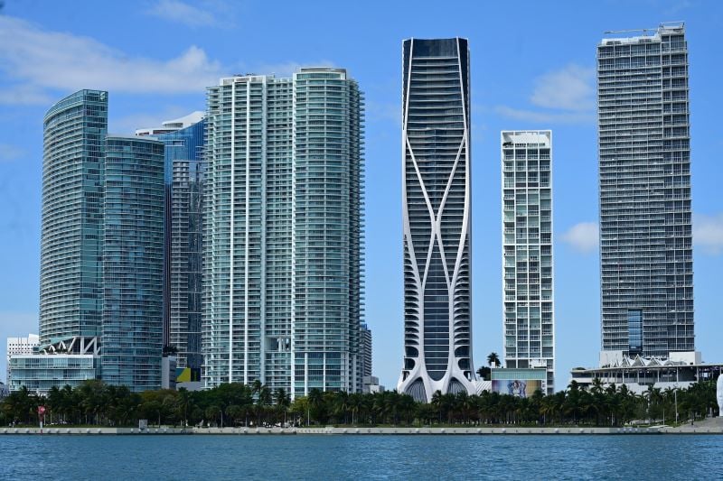 Skyscrapers stand tall in contrast against the blue sky and ocean in Miami.