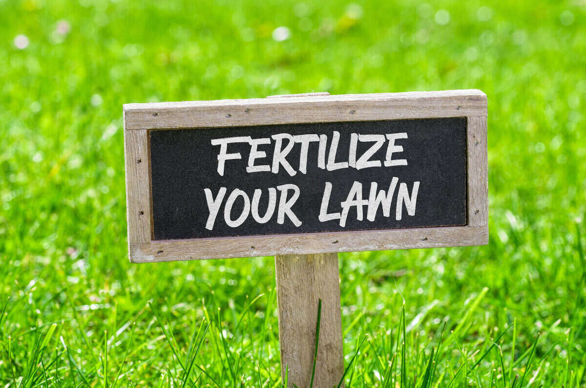 Stake sign in grass that reads "Fertilize Your Lawn"