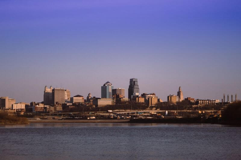 The Kansas City skyline stands between a blue sky and the Missouri River