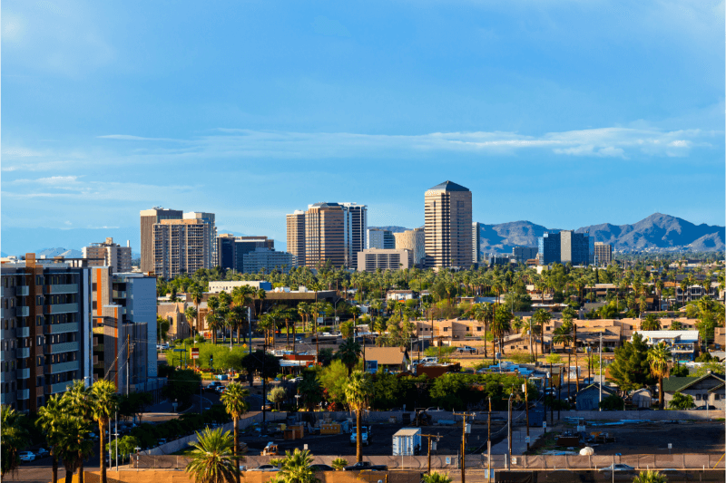 A view of the Scottsdale, Arizona, skyline with mountains in the background and homes and palm trees in the foreground