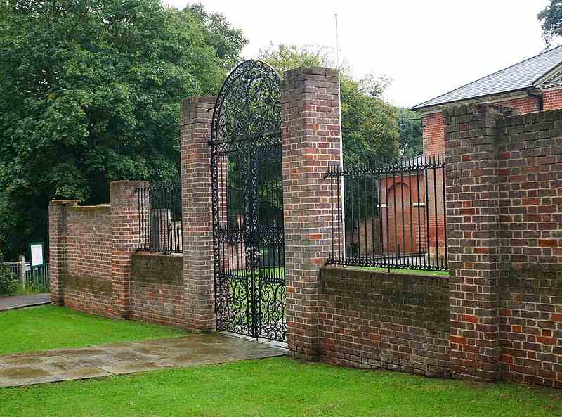 A masonary fence installed in a lawn of  a house