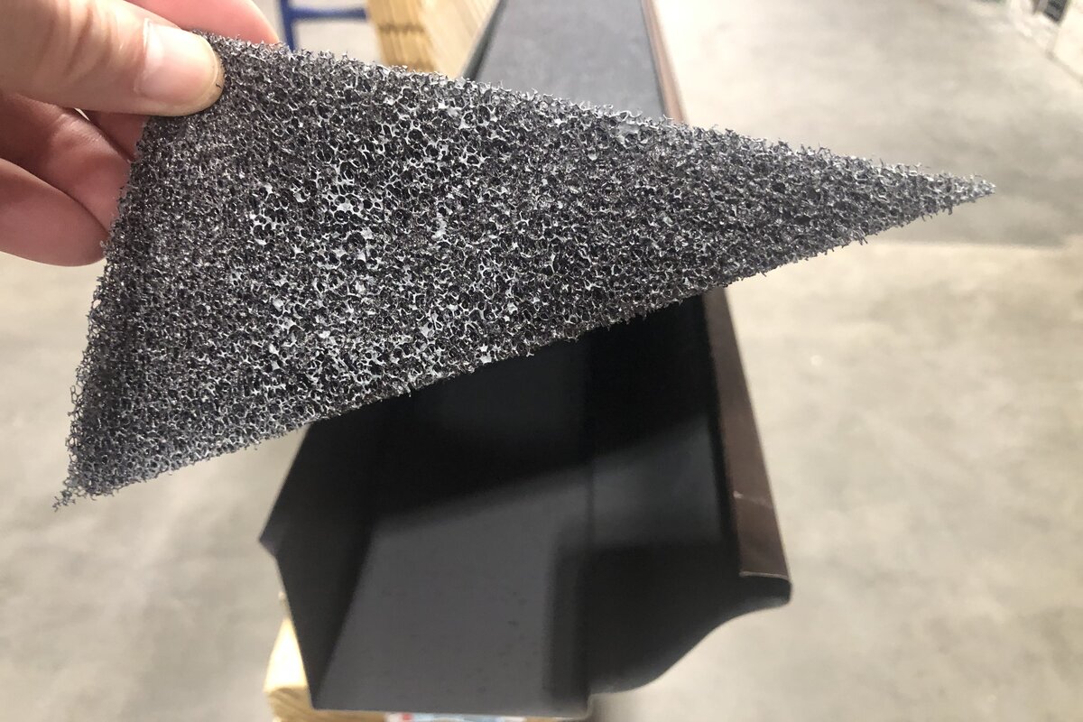 Text: Foam Gutter Guard | Background Image: Man Holding a Foam of gutter guard
