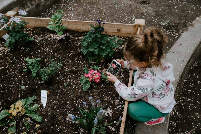 girl taking picture in a garden