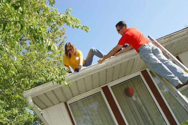 Man and Woman cleaning mold from gutter