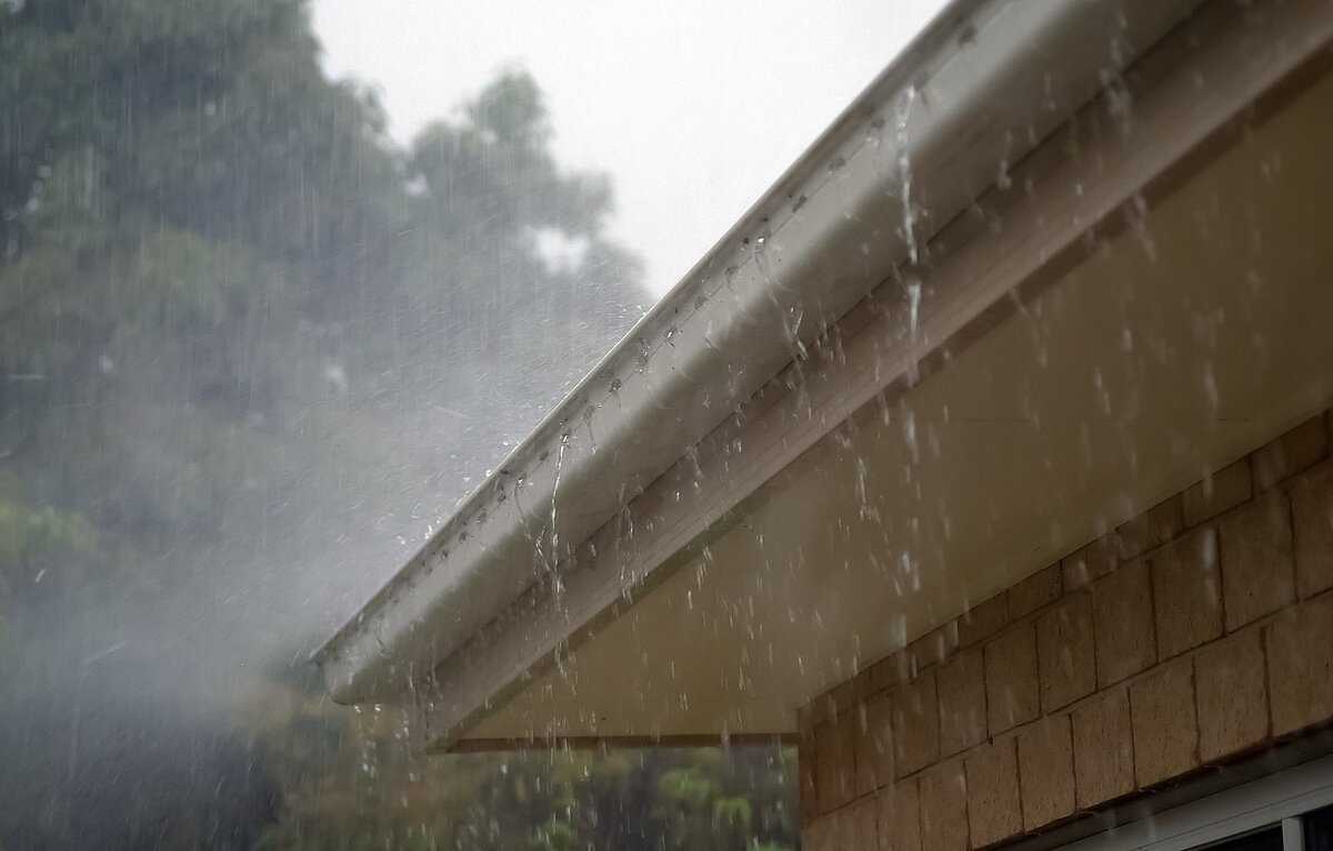 A rain storm pouring on the roof of a house