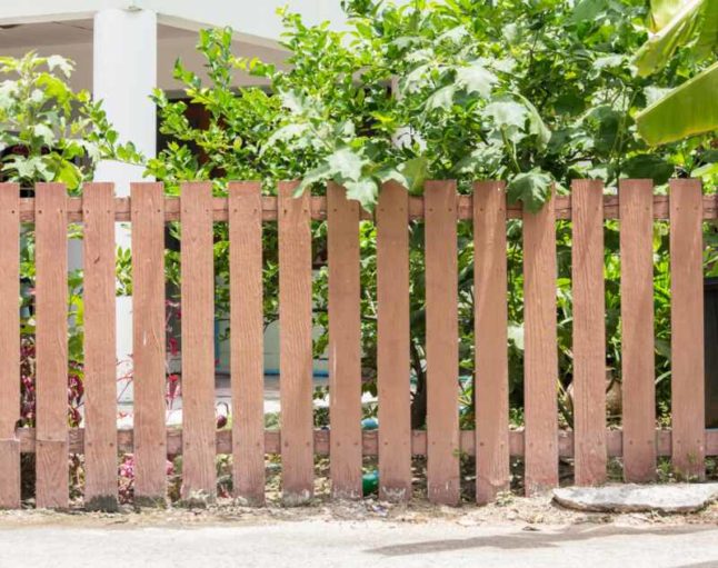 A gorgeous light brown colored  wooden fence of a lawn