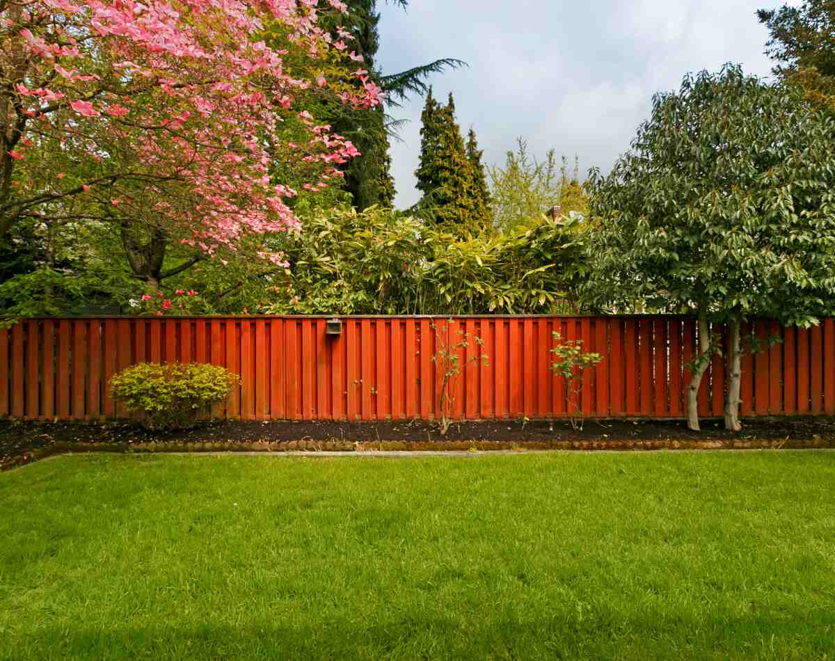 A orange colored fence covering a lawn