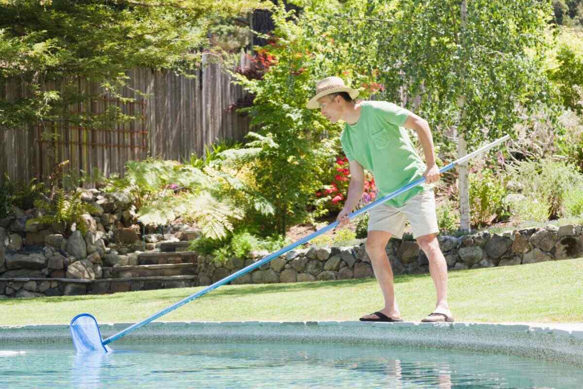 man cleaning pool