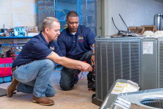 Two men working on an HVAC