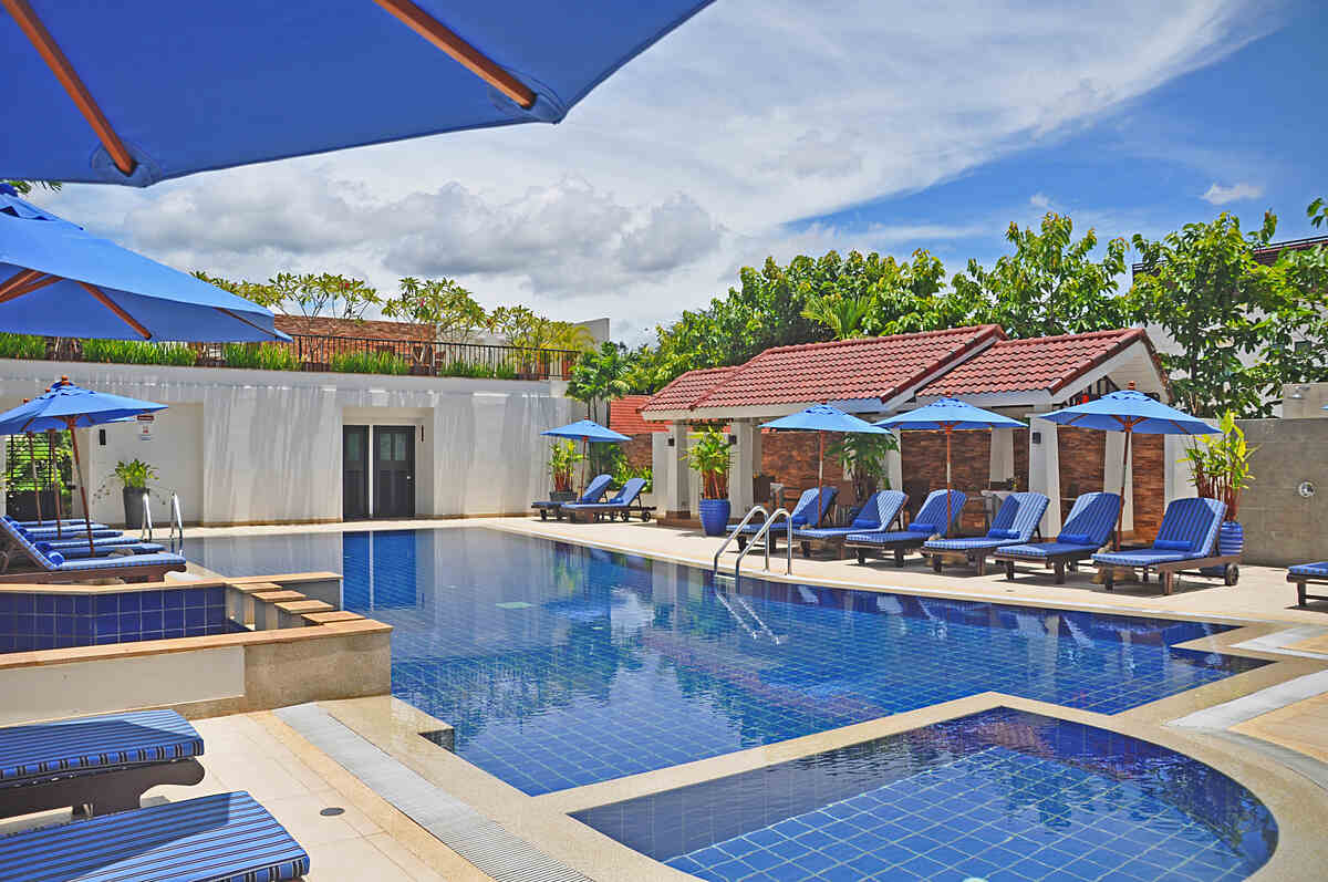 a picture of saltwater pool with chairs and umbrellas nearby