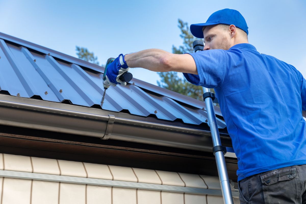 Man in Blue Shirt Installing Metal Roof