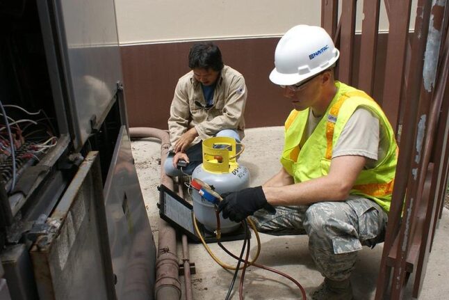 HVAC specialists monitor refrigeration weight and pressure of a chiller in order to correctly recharge the unit.