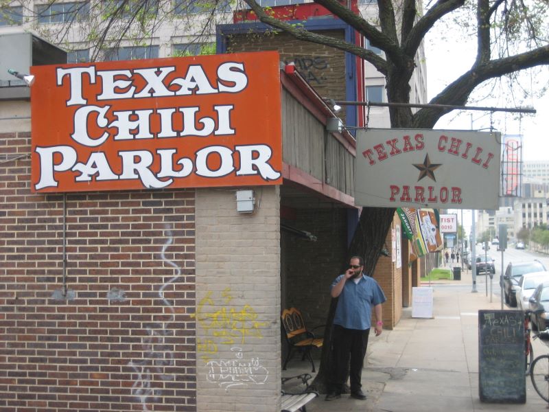 A man stands outside of the Texas Chili Parlor in Downtown Austin.