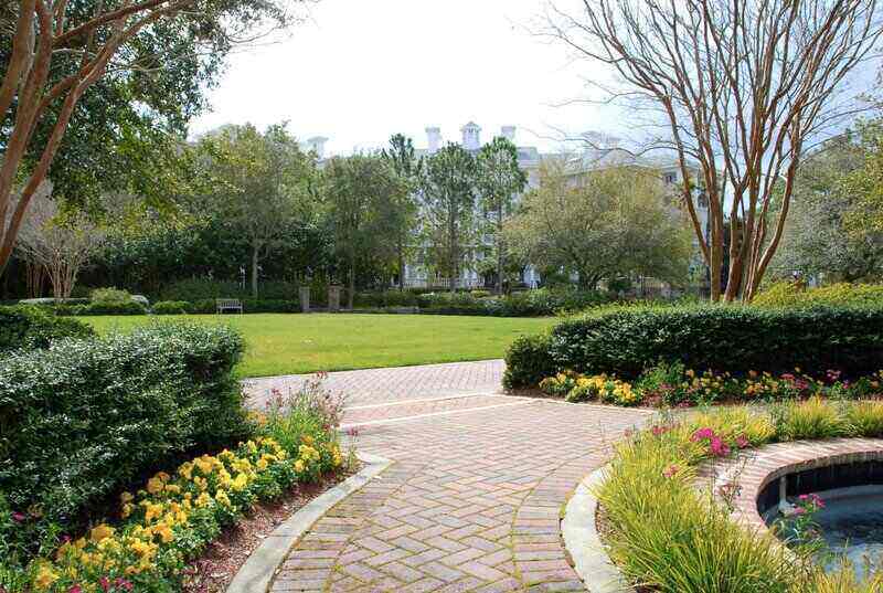 Paver Briks Walkway in the garden with yellow flowers on side 