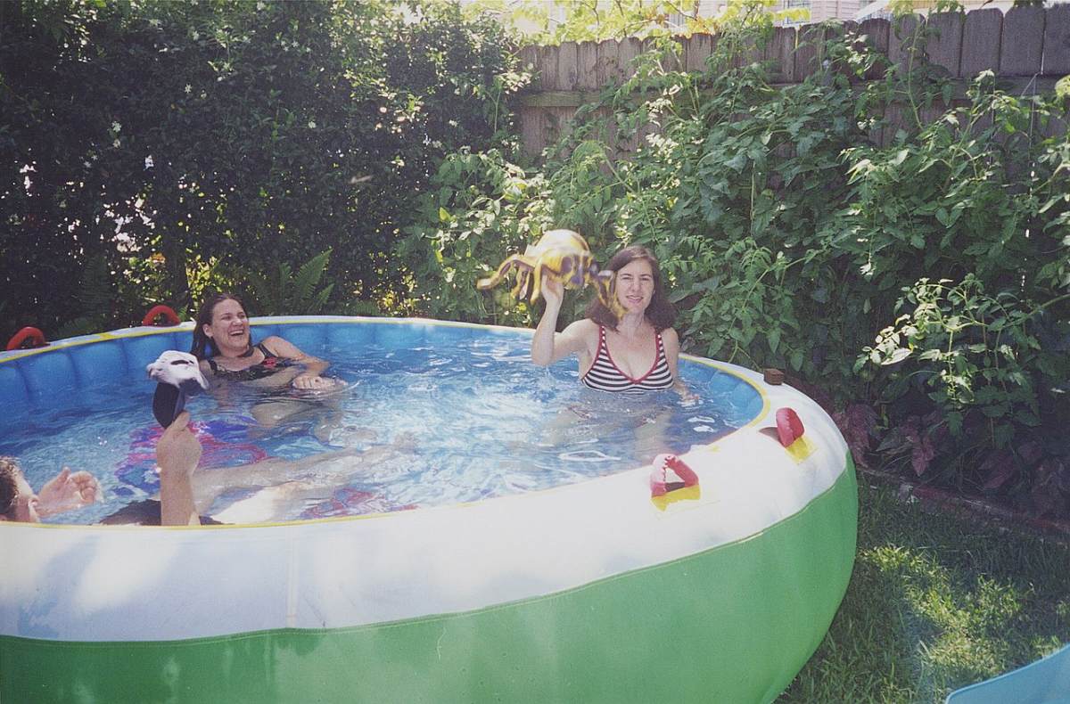 People having fun in an inflatable pool in a backyard