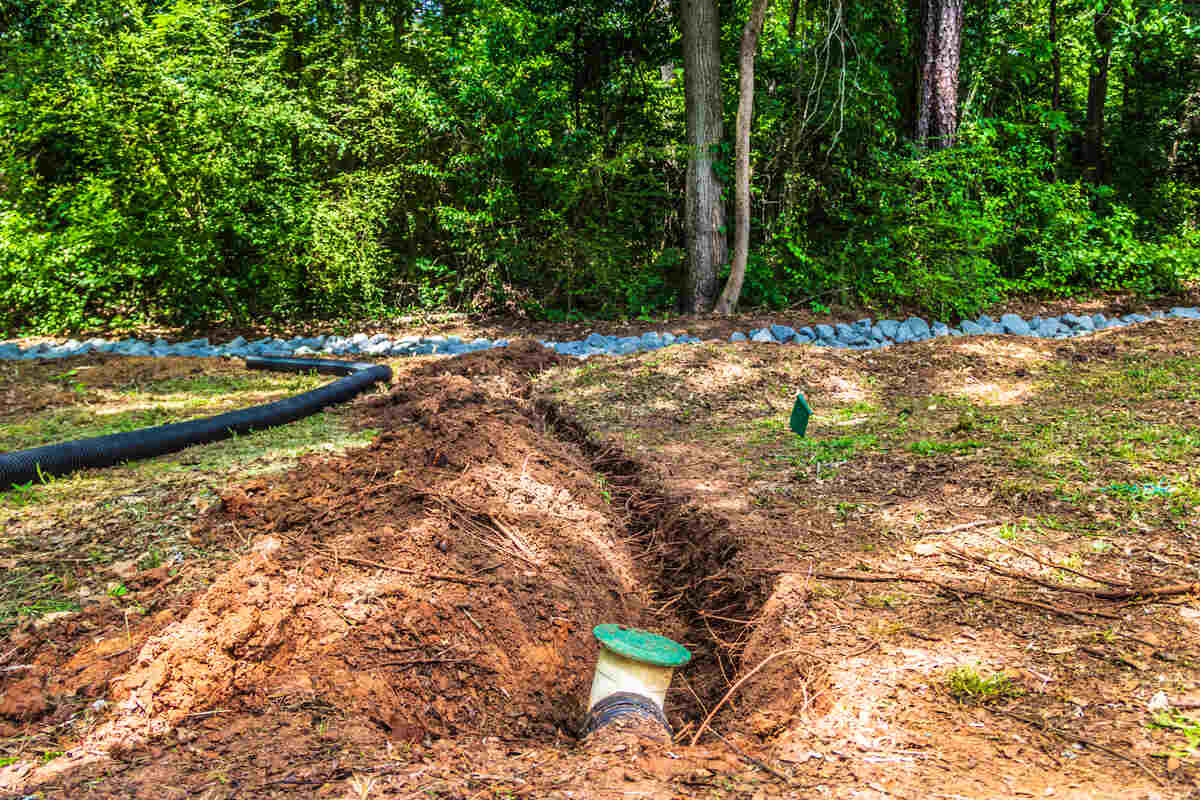 French drain with pop up valve in ground with trench dug for an extension to be added