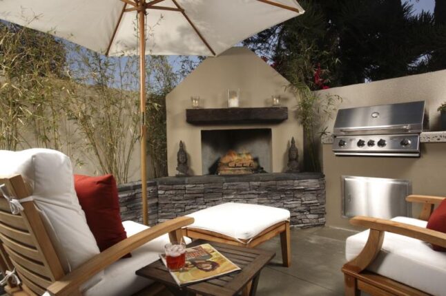 Fireplace with a kitchen, two comfy chairs with a table and an umbrella