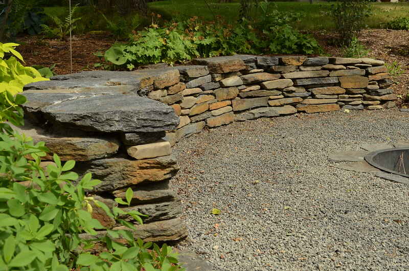 A natural stone retaining wall in a yard of house