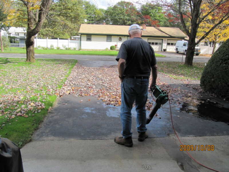 person blowing leaves out of the house
