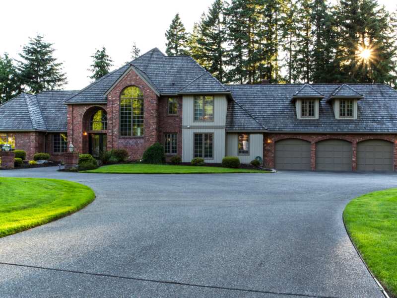 A driveway with lush green vegetation on its edges