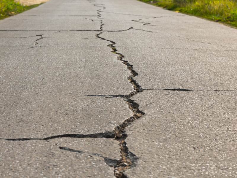A driveway with large cracks on it