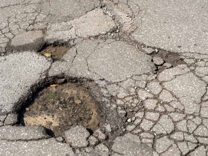 A driveway with a pothole in it.