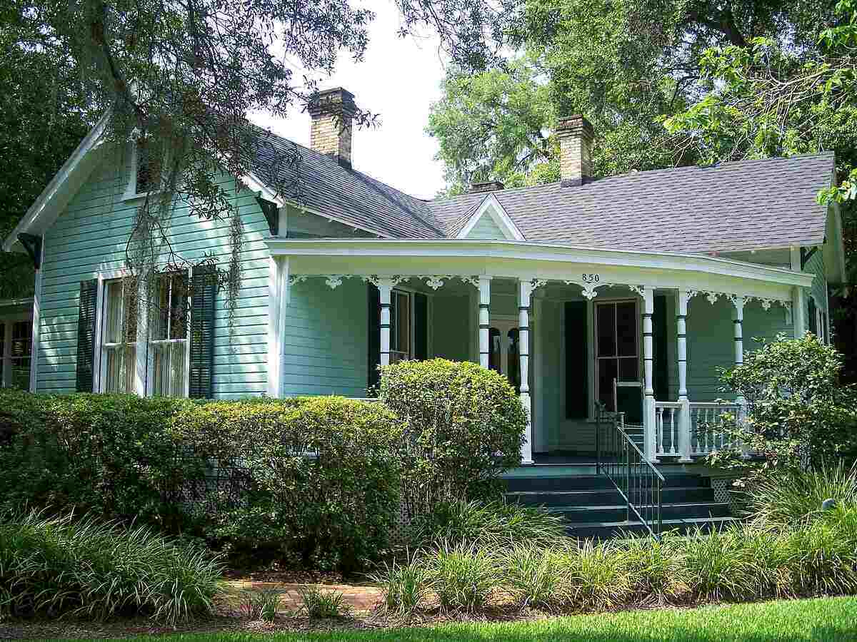 A mint-green-colored home in the historic district of Ocala, Florida, with a big rounded porch.