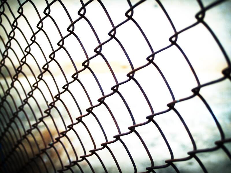 A black chaiin link fence installed at a boundary