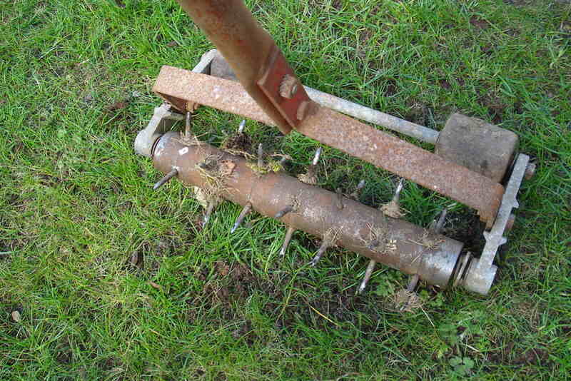 A close up of a tool aerating lawn