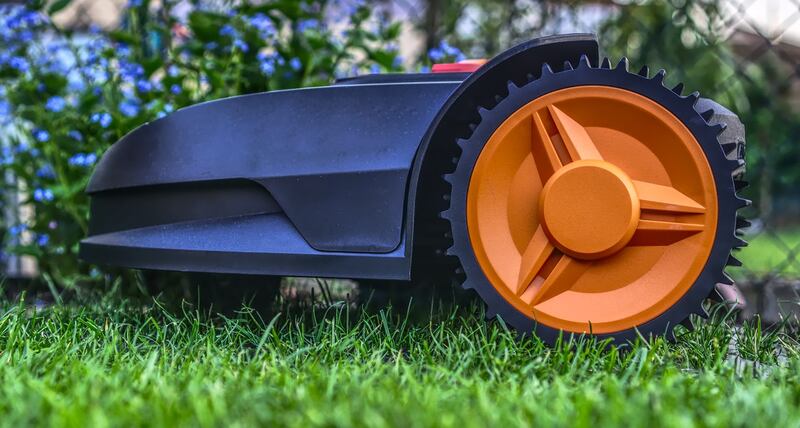 A lawn mower trimming grass