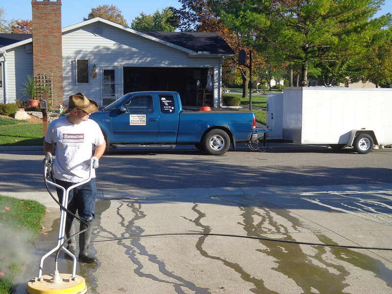 A person pressure washing his driveway