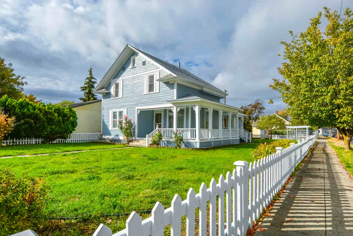 A Victorian cottage with a white picket fence and covered front porch and deck in the Spokane, Washington area of the Inland Northwest, USA.