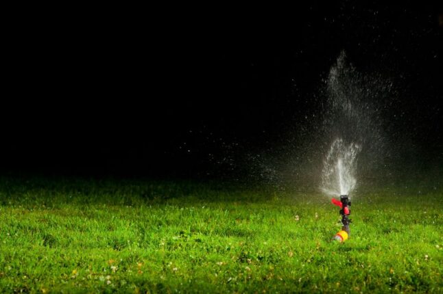 Lawn water sprinkler at nighttime