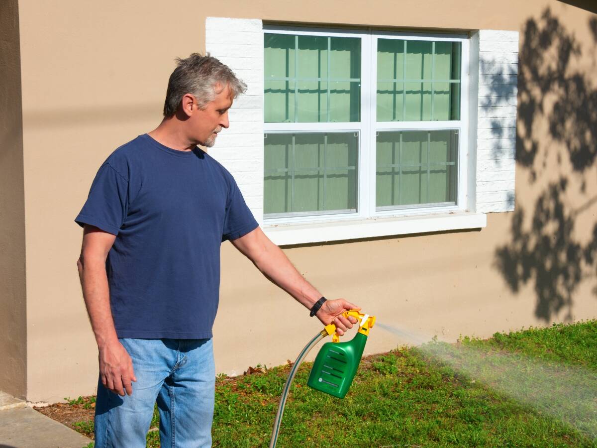 A man spraying weed killer in his lawn