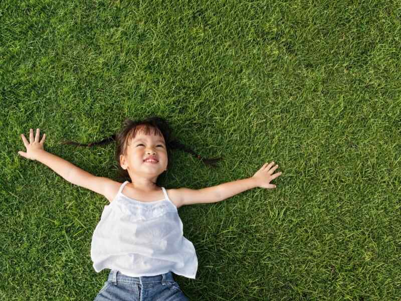 little girl laying on grass