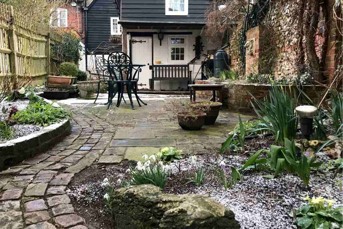 cottage with frozen ground and blooming flowers