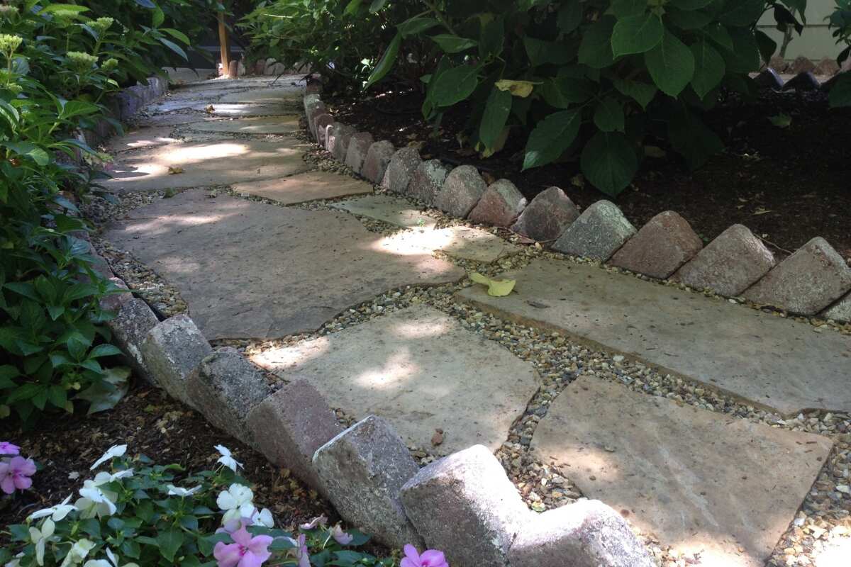 Stone walkway through flowers and greenery